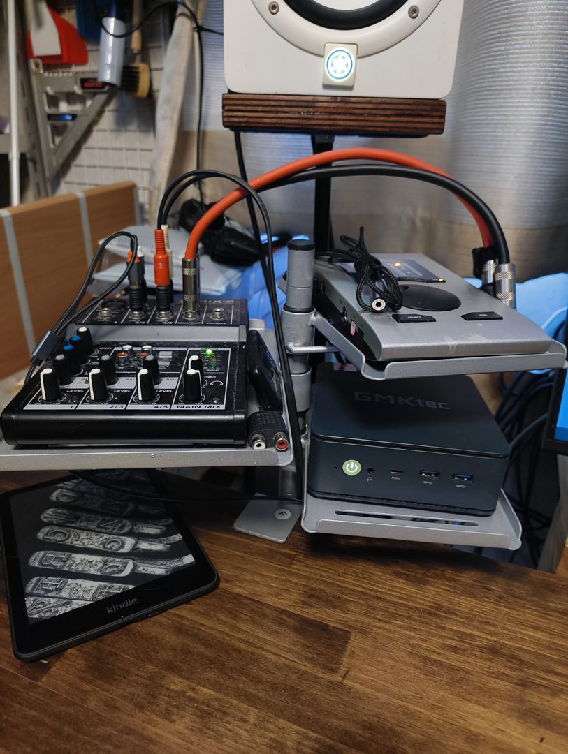 デスクに取り付けられたインターフェーススタンド。ミニPC、小型ミキサー、オーディオインターフェースが設置されている。