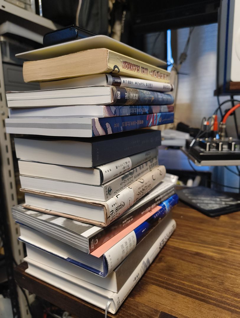 デスク上に置かれた積読ホルダー。15冊ほどの本がつめこまれている